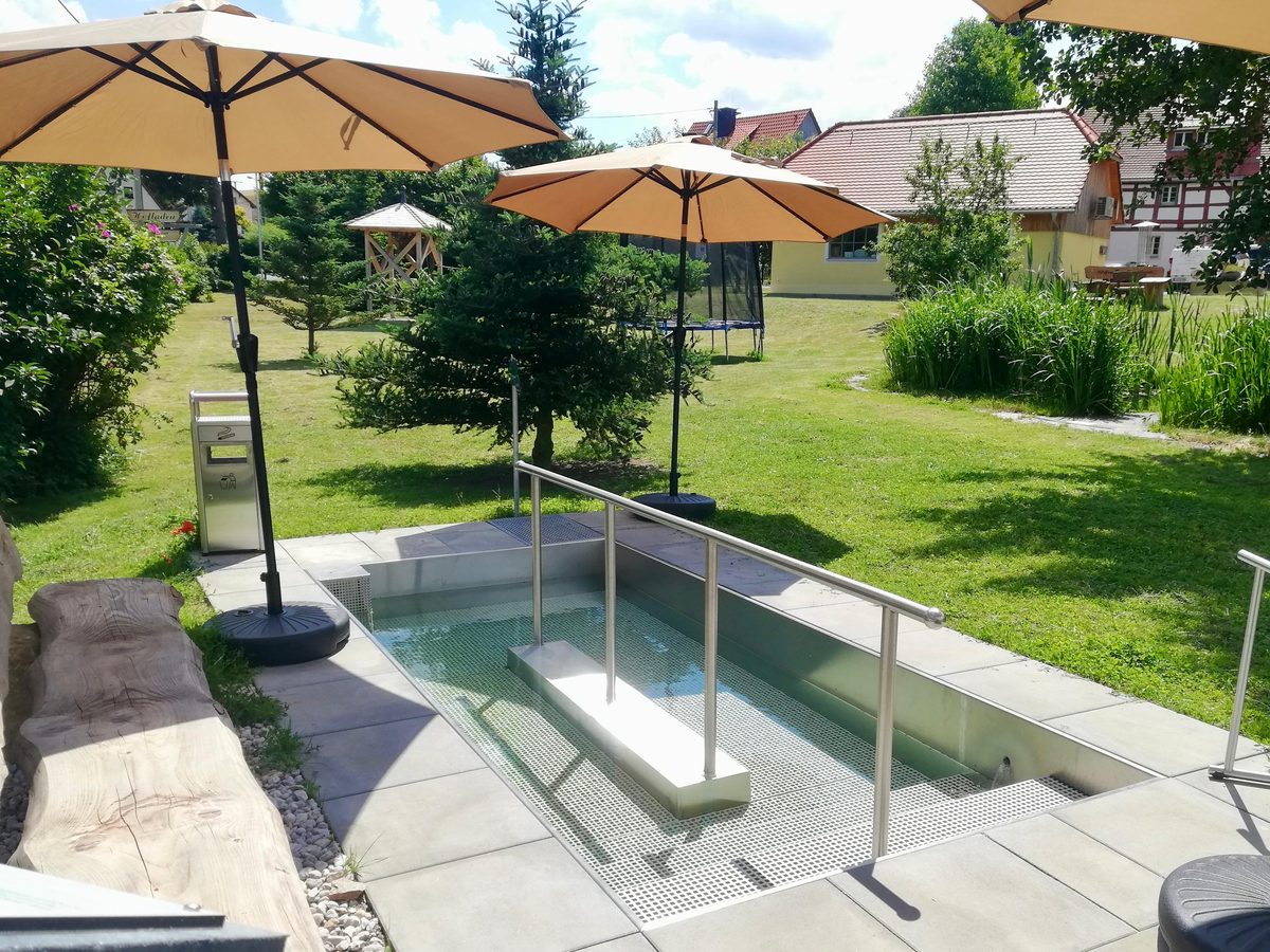 Kneipp-Becken im Garten mit Holzbank