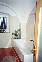 Eingebaute Badewanne unter weißem Kellergewölbe